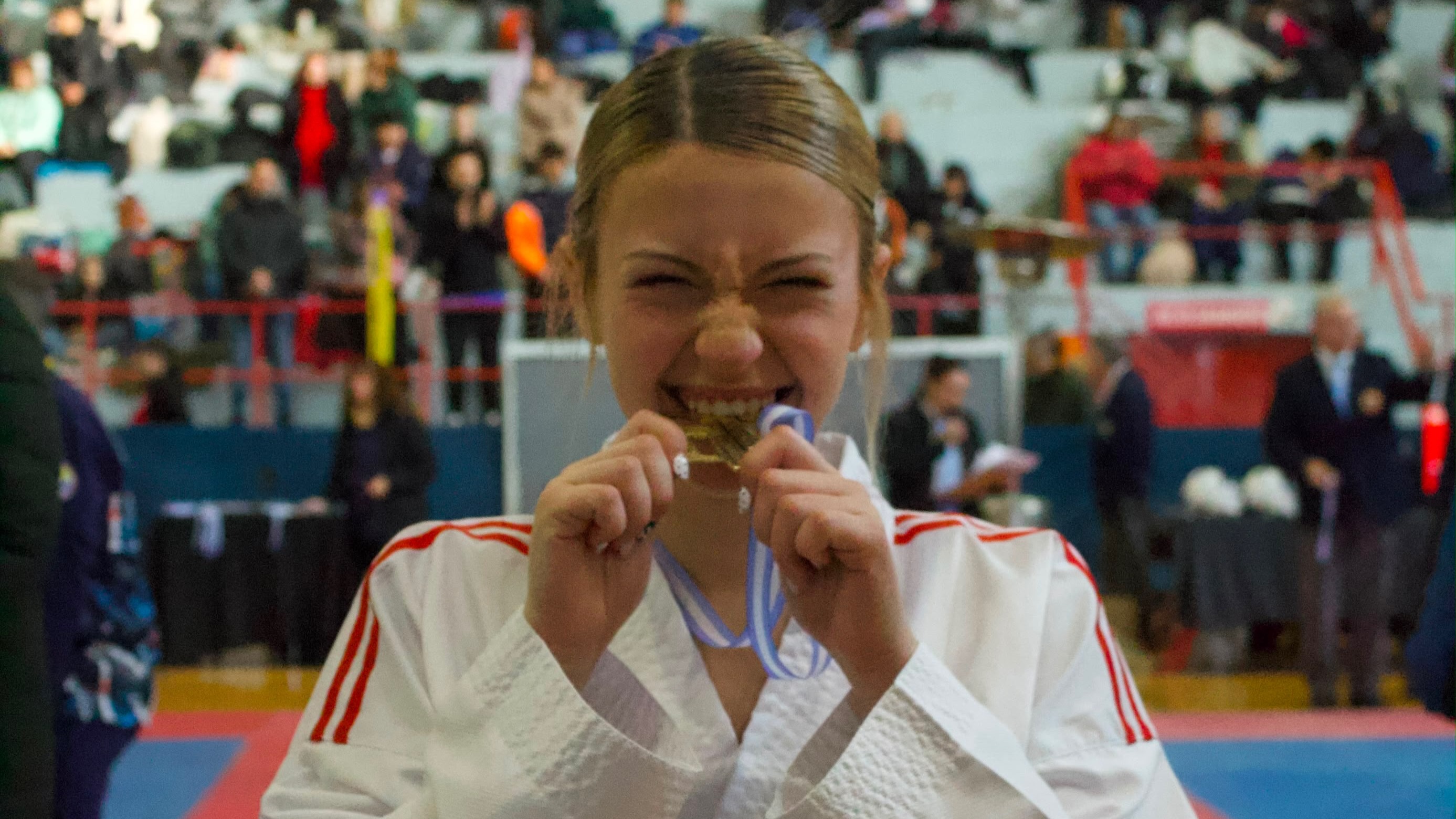 Iara Refsgaard mordiendo la medalla dorada tras consagrarse tricampeona en Córdoba