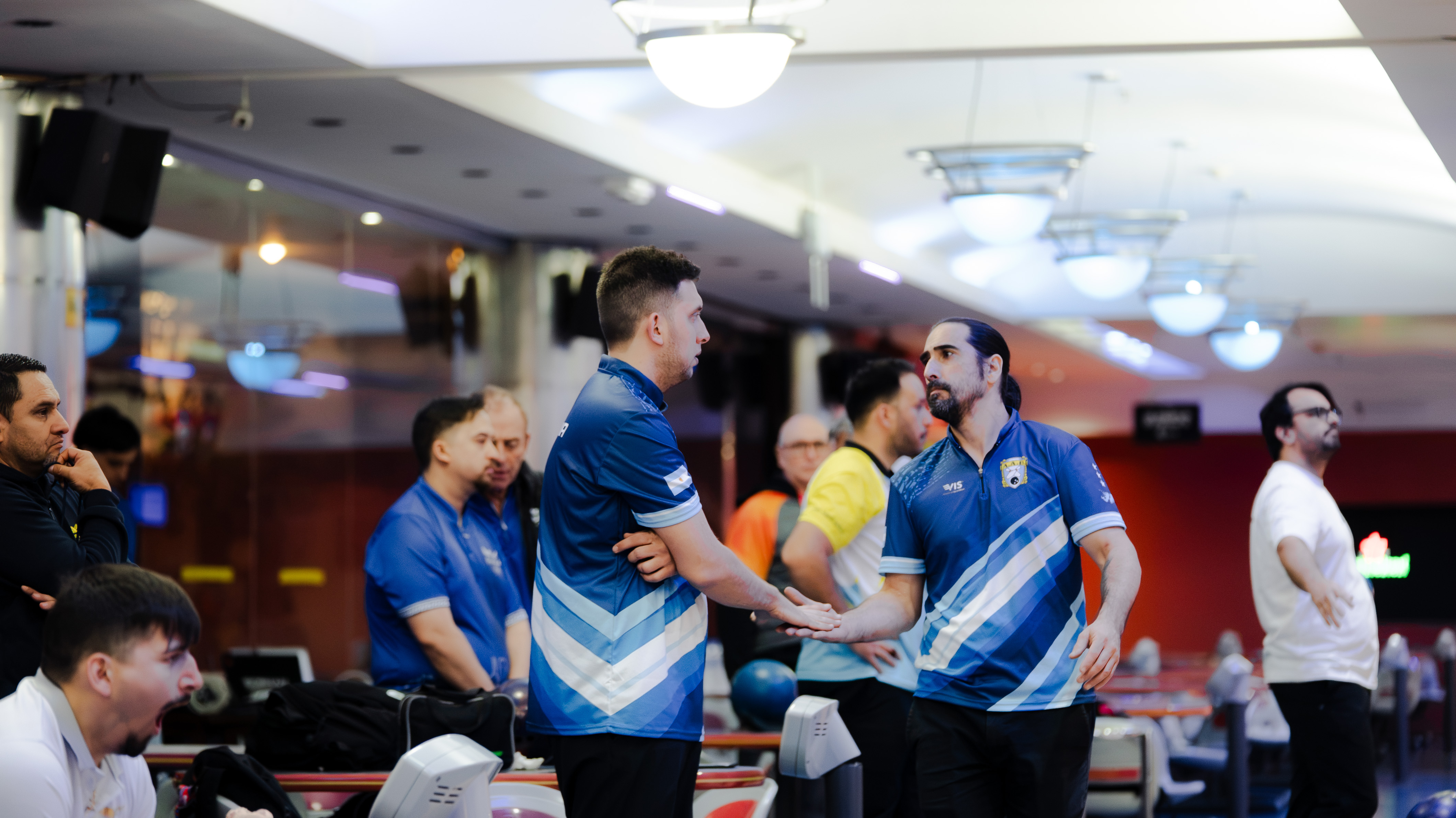 El saludo entre Alexis Plakoudakis y Lucas Legnani en el sector de jugadores