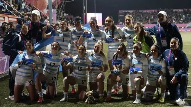 El seleccionado argentino femenino de rugby seven completo junto a su staff técnico festejando la corona suramericana