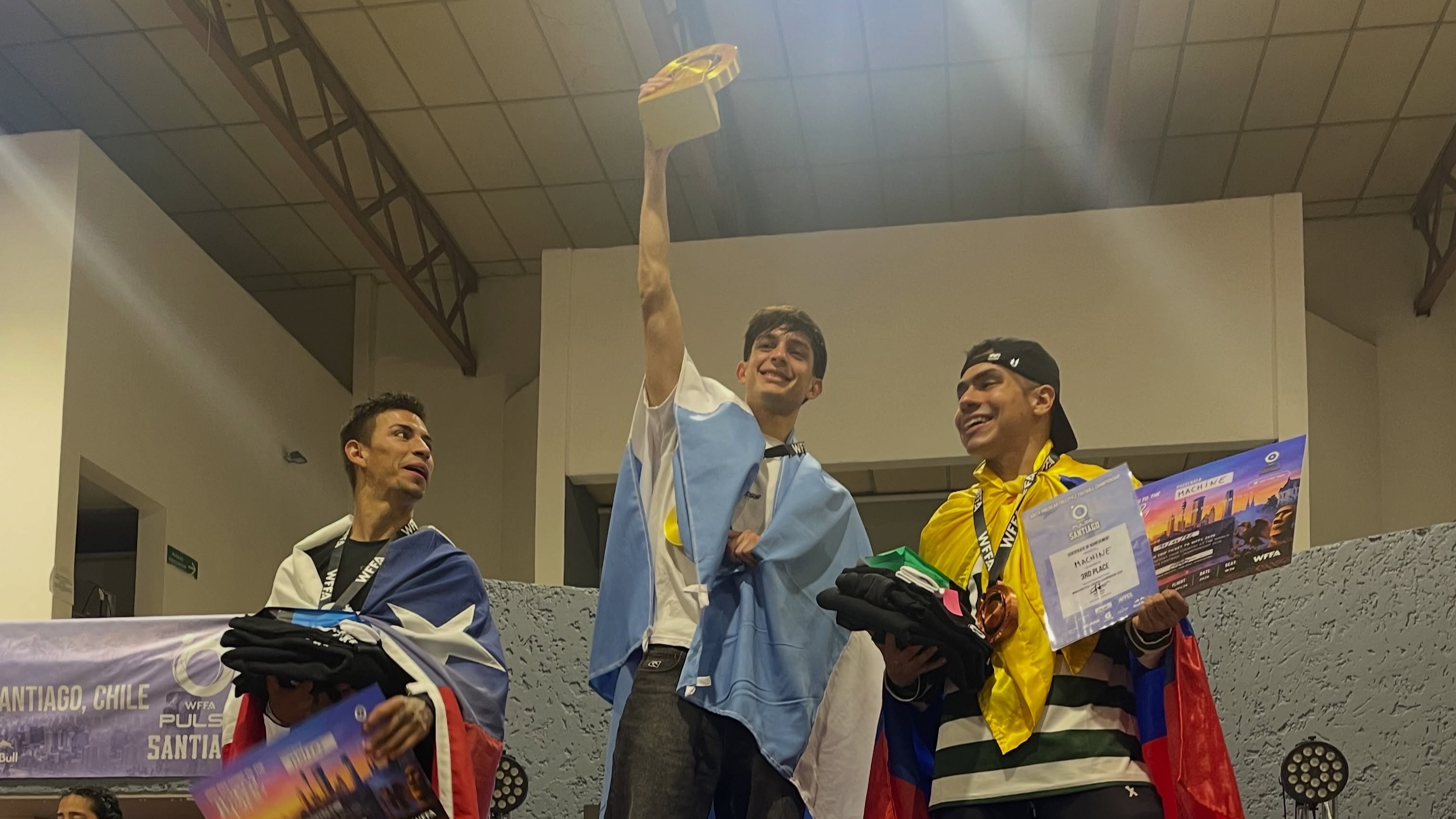 Ignacio Chávez en lo más alto del podio celebrando con el trofeo y la bandera argentina. (Foto: @pandremour)