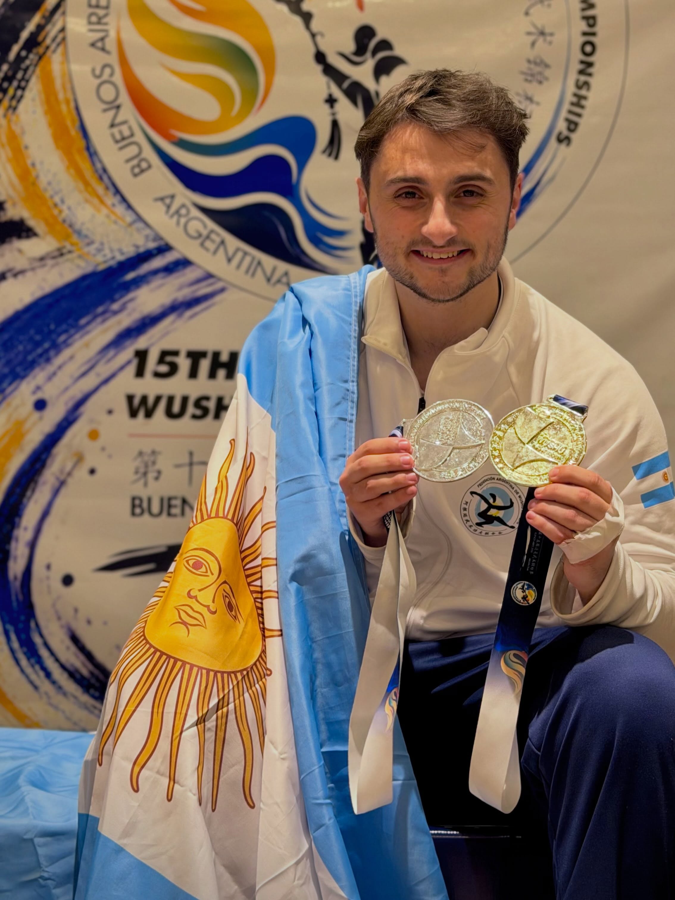 Nelso Carella posando sonriente con la medalla de oro y la de plata obtenidas en el Panamericano, vistiendo los colores de la Selección Argentina.