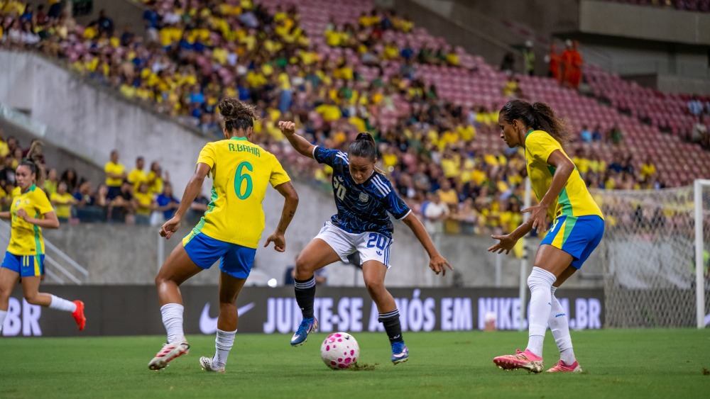 Acción disputada en la mitad de la cancha entre Dalila Ippolito, Daiana Falfán y Bia Zaneratto.